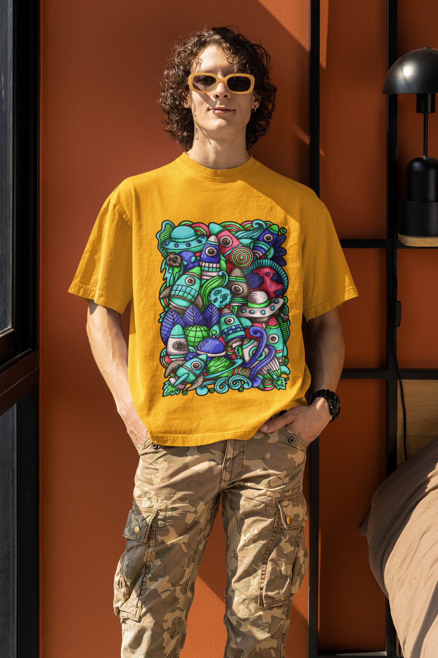 Colorful alien rocket printed on mustard t-shirt.